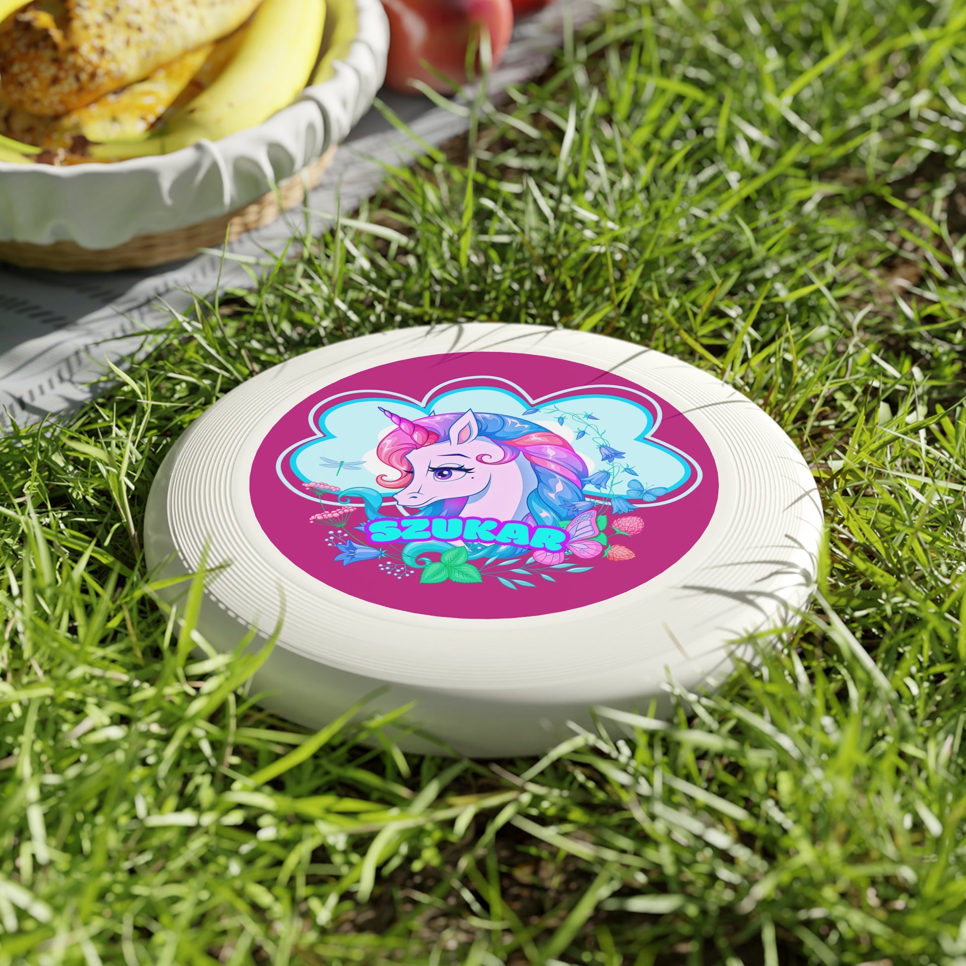 Black frisbee featuring a bold circular pattern with a playful pink unicorn at the center.