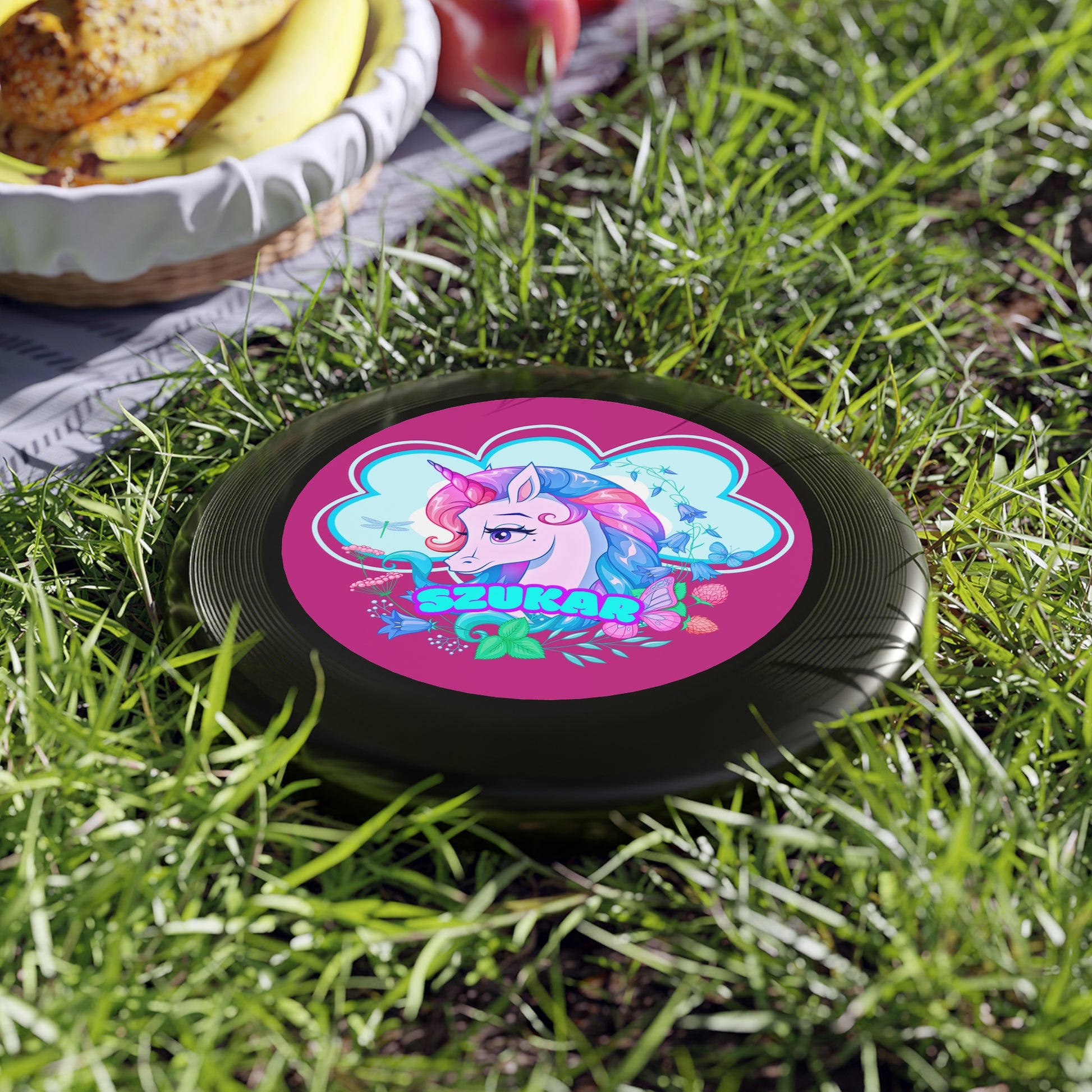 Classic black frisbee featuring a striking round design and a fun pink unicorn illustration.